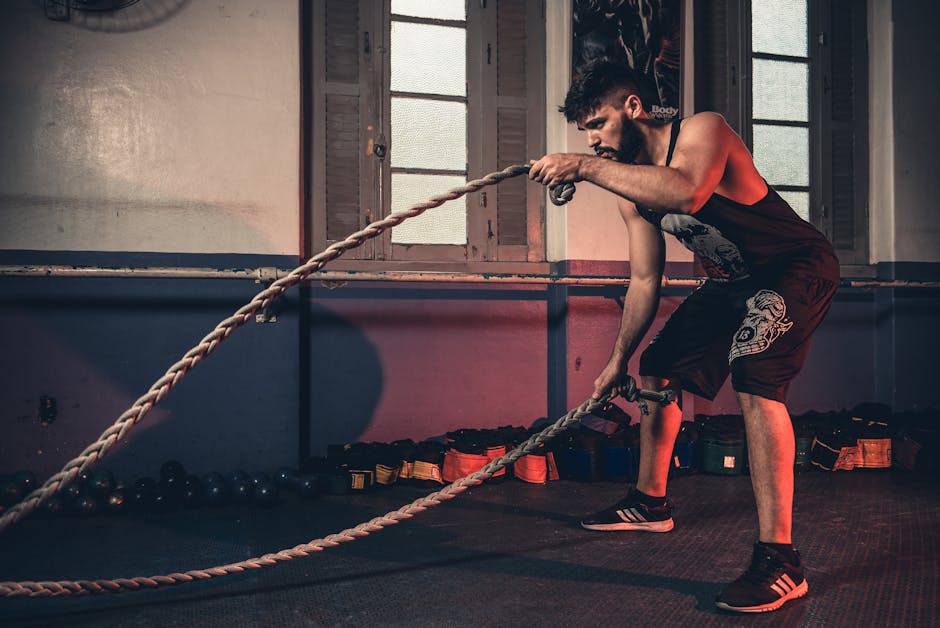 Man performing a challenging Crossfit rope exercise in an indoor gym setting