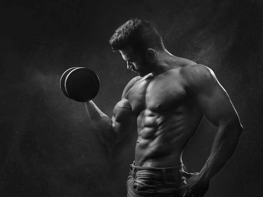 Powerful black and white portrait of a shirtless bodybuilder lifting dumbbells in the gym