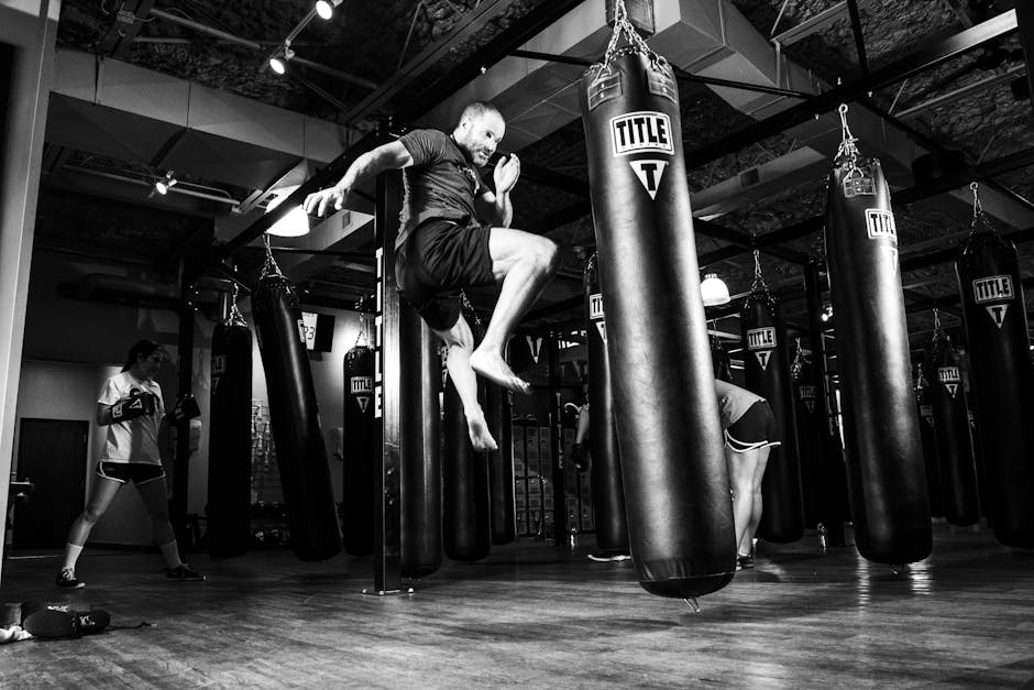 Action-packed scene of a man training in a gym with punching bags.